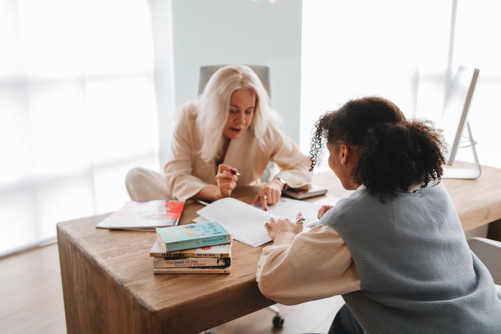 A teacher and student talking across a table